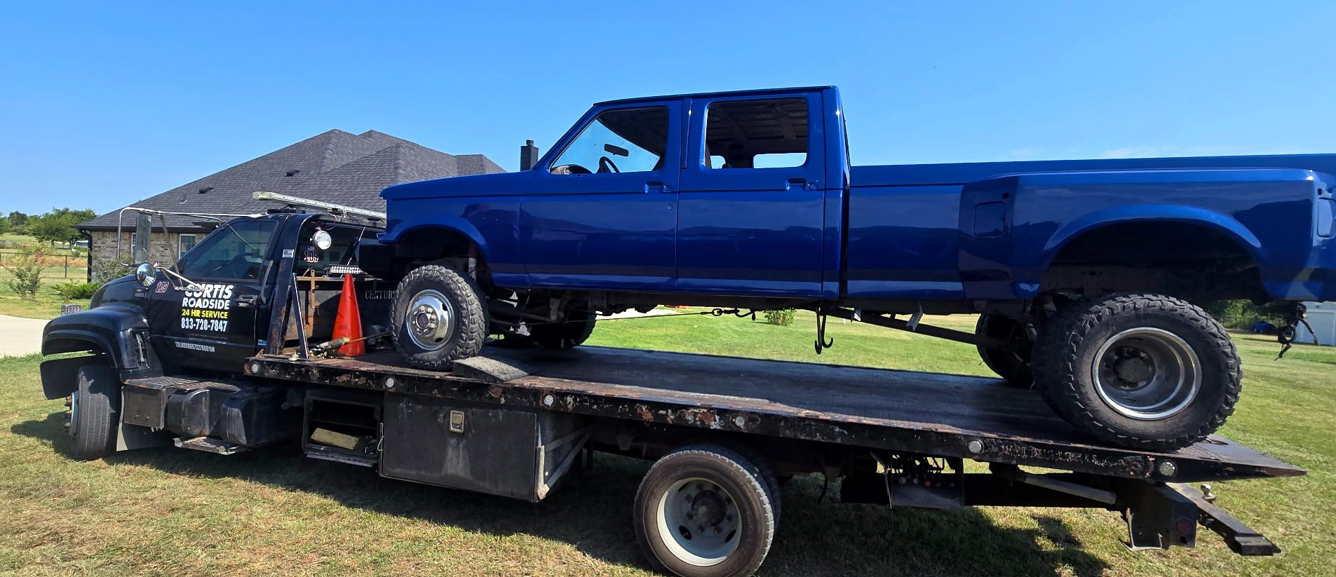 Blue project pickup loaded on a Curtis Roadside flatbed