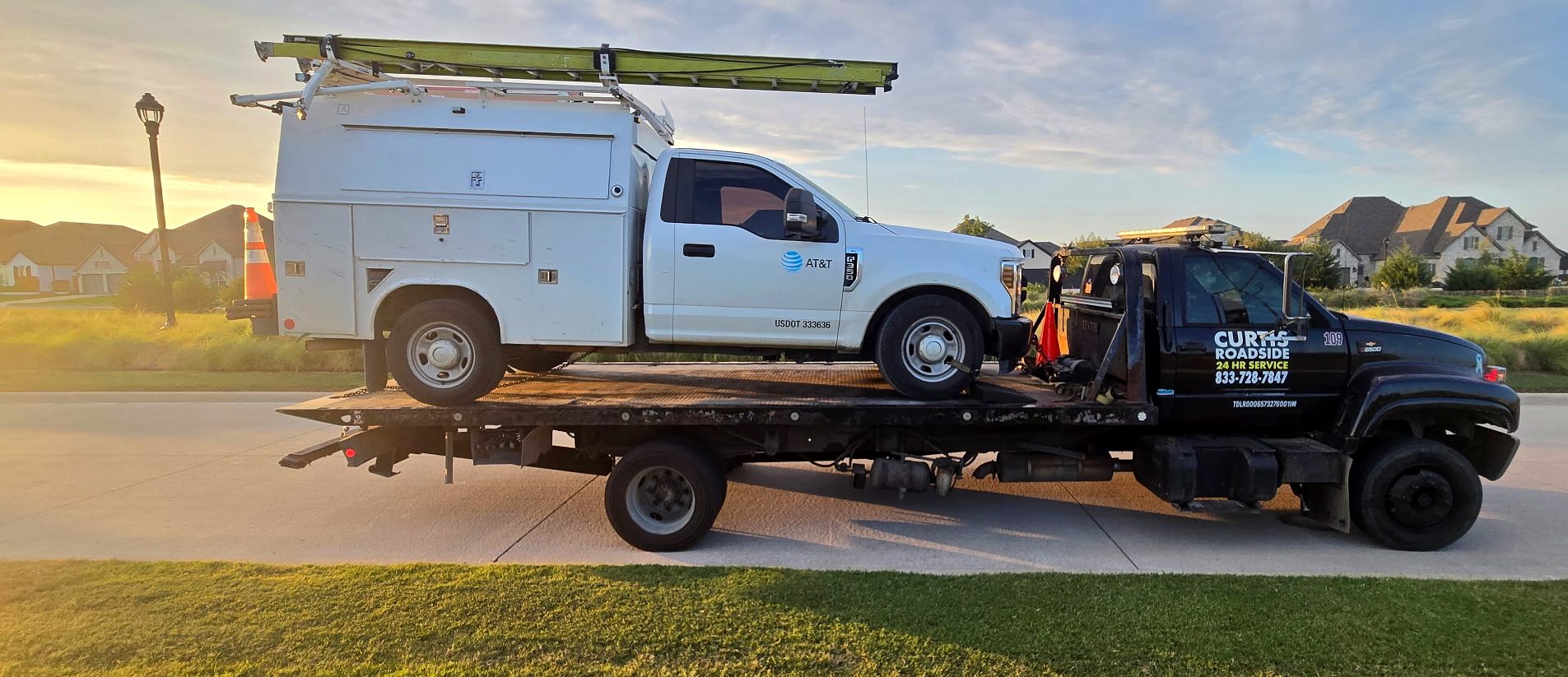 AT&T utility truck secured on a Curtis Roadside flatbed at golden hour